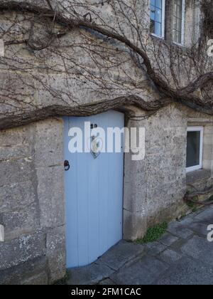 an elegant old stone cottage with a light blue door Stock Photo - Alamy
