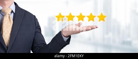 five star, Feedback, review and rating concepts. businessman holding five stars in the palm of his hand. Best Excellent Services for Satisfaction pres Stock Photo
