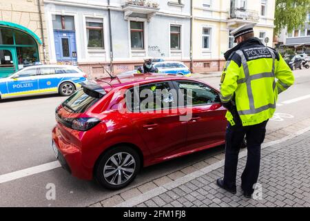 Freiburg, Germany. 05th May, 2021. Two police officers check a car driver after he has overtaken a cyclist with too little distance. This year, the cross-state campaign 'sicher.mobil.leben' (safe.mobile.living) focuses on cycling safety. Credit: Philipp von Ditfurth/dpa/Alamy Live News Stock Photo