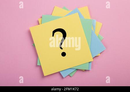 Question mark drawn on notepad. Over pink background with copy space. Stock Photo