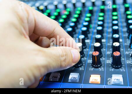 hands of Men are controlling the console of a large hi-fi system. Sound equipment. Control panel of a digital studio Stock Photo