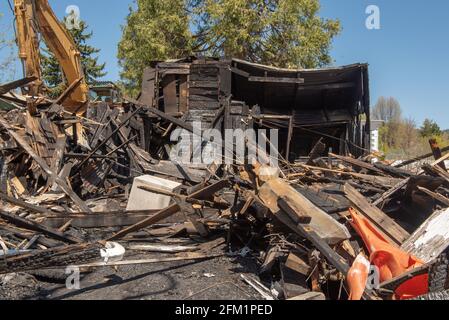 House in ruins from a fire, demolished, on a blue, cloudless sky Stock Photo
