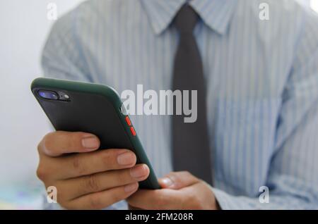 Close up hand holding businessman using mobile smart phone communicate online browse internet. Stock Photo