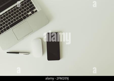 Computer laptop smart phone and mouse and pen on background top view.Copy space. Stock Photo