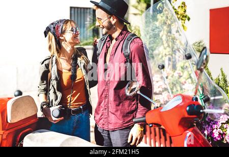Young tourist couple having fun together at scooter moped ride - Hipster guy having fun outdoors with beautiful girlfriend - Happy travel mood and lif Stock Photo