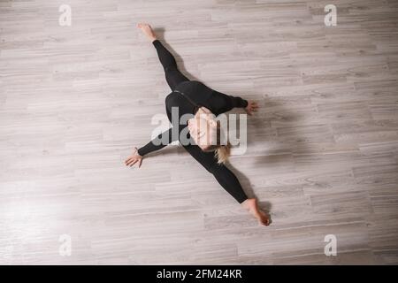 Top view shot of a female gymnast doing splits on the floor Stock Photo