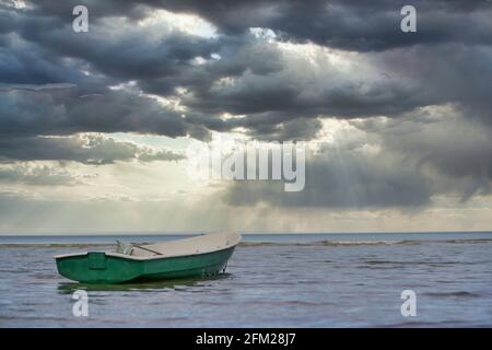 Green small boat. Green boat tied in water with a lot of highlights around Stock Photo