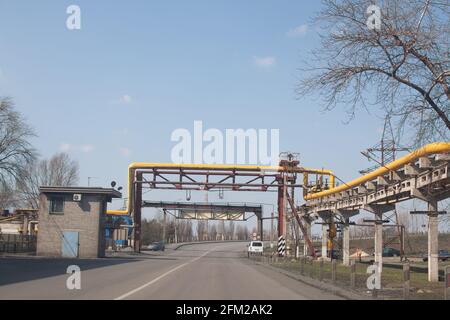 A road along an industrial site. Pipeline overpass.  Stock Photo