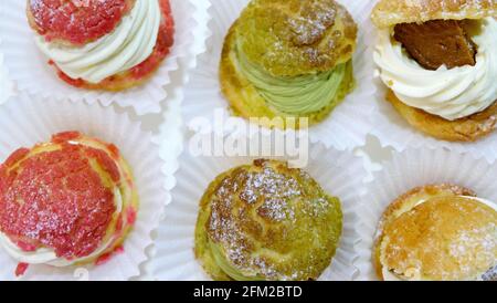 Closeup of 6 cream puffs of different flavor. Stock Photo