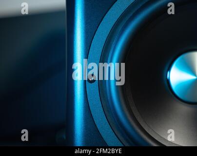 Front close up view of modern sub-woofer with blue highlights. Close-up of bass speaker. Music, sound concept. Stock Photo