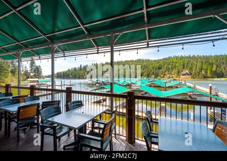 A waterfront cafe patio overlooking a community of homes and docks on the lake at Rockford Bay in the mountain community of Coeur d''Alene, Idaho, USA Stock Photo