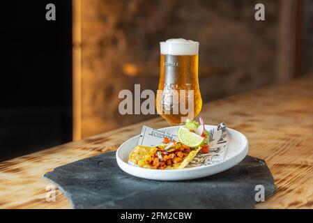 Arinsal, Andorra : 2021 April 29 : Beer accompanied by a taco al Pastor. Typical Mexican food Stock Photo
