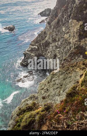 Panoramic shot of the beautiful Big Sur Coast of California on a misty day, United States of America aka USA. Foamy waves in the ocean and rocky mount Stock Photo