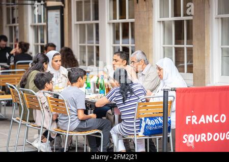 Tourists having lunch at tables outside a cafe on Cambridge Street. Cambridge, UK, August 1, 2019. Stock Photo