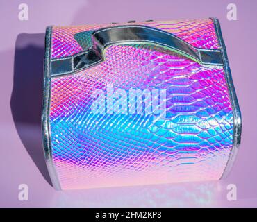 Cosmetic case on abstract background with holographic bright rainbow multicolor. Metallized macro close up. Imitation of rainbow color. Background wit Stock Photo