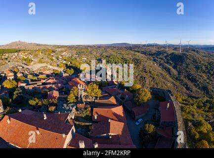 Drone aerial panorama of historic village of Sortelha with castle and with turbines on natural landscape, in Portugal Stock Photo