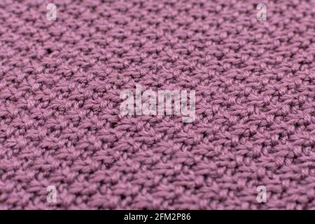 Knitted fabric pearl woolen background, close-up. The structure of the fabric with a natural texture. Fabric background. Knitted woolen background Stock Photo