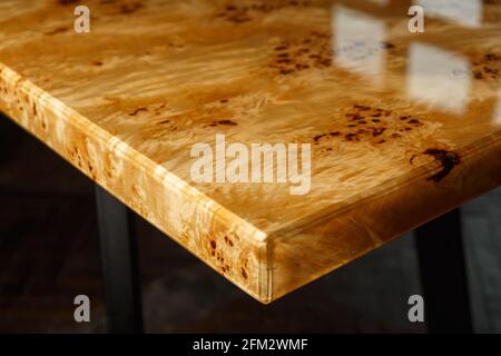 Table top for a table made of poplar burl wood and transparent epoxy resin. The resin is varnished and polished, the wood is saturated with tung oil. Stock Photo