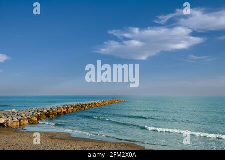 The Mediterranean sea and rocky breakwater on the beach of Cabopino, Marbella, Malaga. Stock Photo