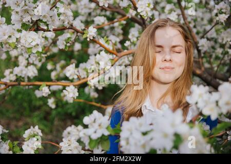 A young woman rejoices in the sun and puts her face to the sun.  Stock Photo