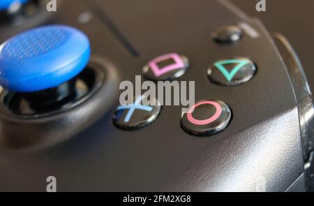 Krakow, Poland- April 13, 2021: A close up extreme selective focus of the iconic Play station buttons on a wireless controller. The square, cross, tri Stock Photo