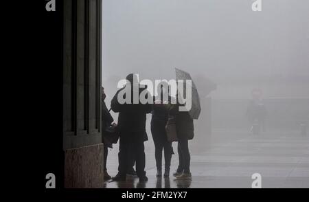 Domestic and International tourists wearing facemarks are visiting the monastery of Montserrat during a misty and rainy spring day, at the end of the pandemic induced Spanish State of Emergency in the Montserrat mountain range, west of Barcelona in the province of Catalonia, Spain. © Olli Geibel Stock Photo