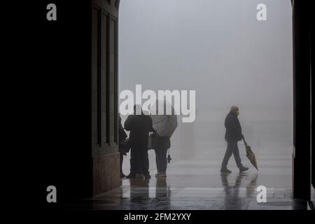 Domestic and International tourists wearing facemarks are visiting the monastery of Montserrat during a misty and rainy spring day, at the end of the pandemic induced Spanish State of Emergency in the Montserrat mountain range, west of Barcelona in the province of Catalonia, Spain. © Olli Geibel Stock Photo