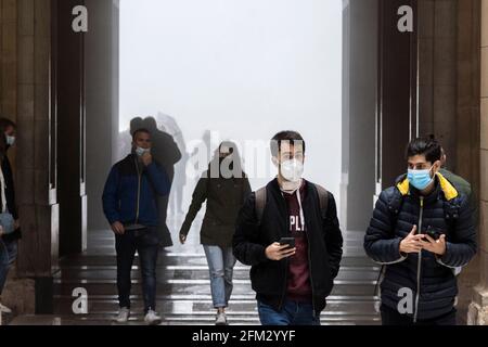 Domestic and International tourists wearing facemarks are visiting the monastery of Montserrat during a misty and rainy spring day, at the end of the pandemic induced Spanish State of Emergency in the Montserrat mountain range, west of Barcelona in the province of Catalonia, Spain. © Olli Geibel Stock Photo