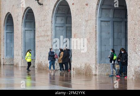 Domestic and International tourists wearing facemarks are visiting the monastery of Montserrat during a misty and rainy spring day, at the end of the pandemic induced Spanish State of Emergency in the Montserrat mountain range, west of Barcelona in the province of Catalonia, Spain. © Olli Geibel Stock Photo