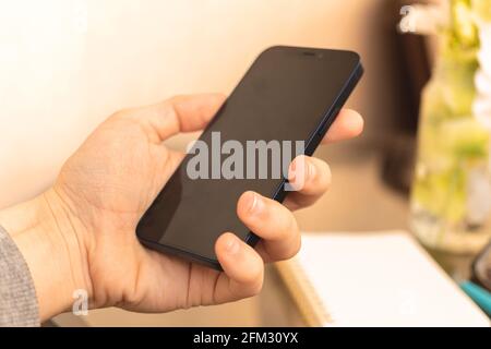 Man using blank smartphone on fashion home interior background Stock Photo