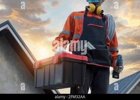 Portrait of an electrician wearing a face mask carrying a toolbox, Thailand Stock Photo