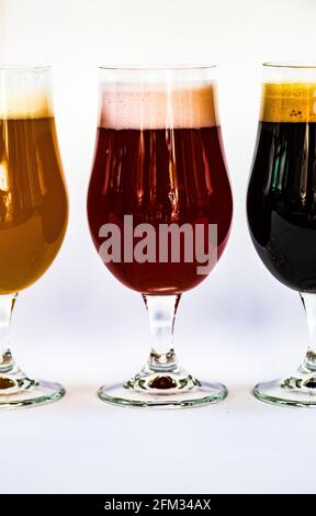 Three different glasses of craft beers lined up on a table Stock Photo