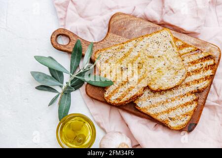 Overhead view of two slices of ciabatta toast with olive oil and fresh garlic Stock Photo