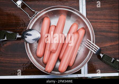 Four sausages frankfurter wurst boiling in hot water in pan Stock Photo