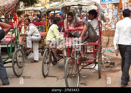 A group of bicycle rickshaw drivers talking and waiting for customers in Chandni Chowk, Delhi, India Stock Photo