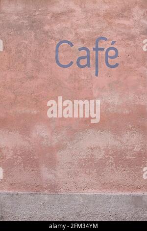 Blue font café sign painted on a deep pastel pink sorbet coloured wall Stock Photo