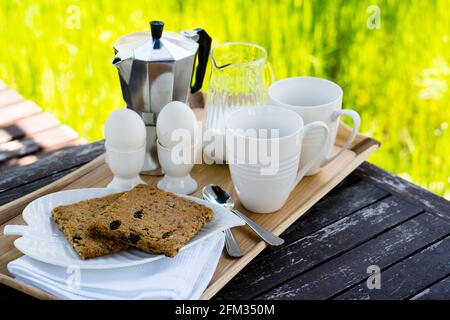 Breakfast for two on an old table in the summer garden Stock Photo