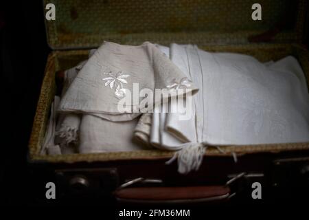 Vintage suitcase with vintage fabrics. Selective focus on fabric in blurred background. Close up Stock Photo