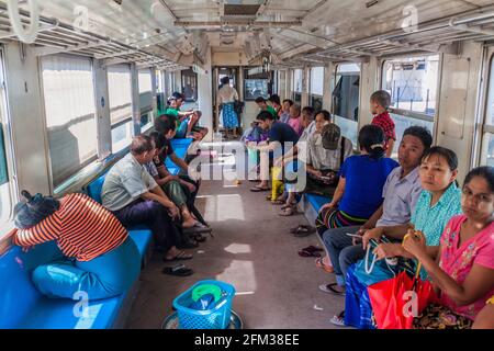 YANGON, MYANMAR - DECEMBER 16, 2016: Commuters in a carriage of a local train on Yangon circle line. Stock Photo