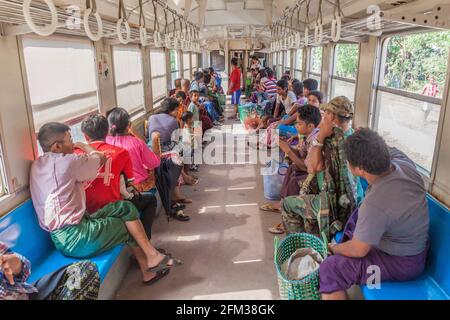 YANGON, MYANMAR - DECEMBER 16, 2016: Commuters in a carriage of a local train on Yangon circle line. Stock Photo