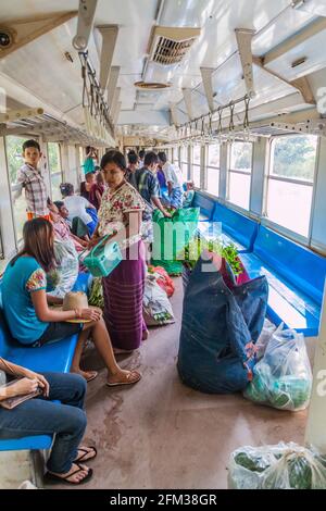 YANGON, MYANMAR - DECEMBER 16, 2016: Commuters in a carriage of a local train on Yangon circle line. Stock Photo