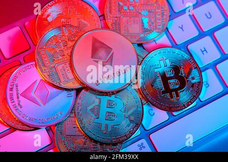 Cryptocurrency bitcoin and ethereum (ether) token coins on a computer keyboard Stock Photo