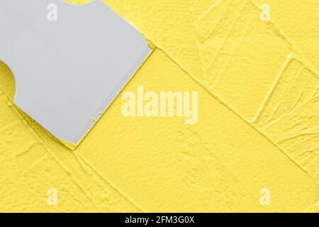Applying yellow putty with spatula, interior redecorating finishing works Stock Photo