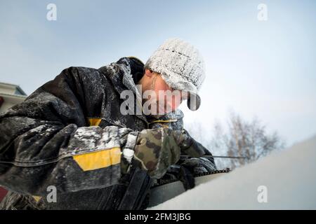 A manual file worker sharpens a chainsaw chain Stock Photo