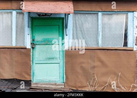 old wooden turquoise door on the front of the house Stock Photo