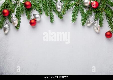 Christmas horizontal banner. Fir tree branches with red and silver christmas balls on white background. Top view. Copy space - Image Stock Photo