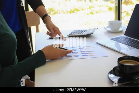 business team hands searching for data on mobile phone  with analyzing charts at his workplace. Stock Photo