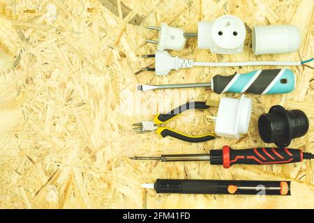 Electric tools are spread out on the table. Electrician or builder tools on a wooden table. The tools of the electrician and the builder are laid out Stock Photo