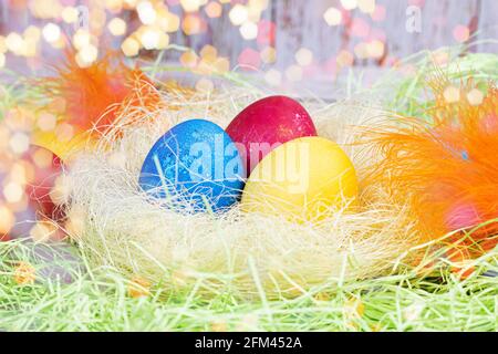 Colorful painted Easter eggs decorations in the nest on light green background. Stock Photo