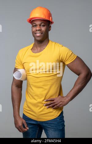 Smiling man in yellow tshirt and protective helmet Stock Photo
